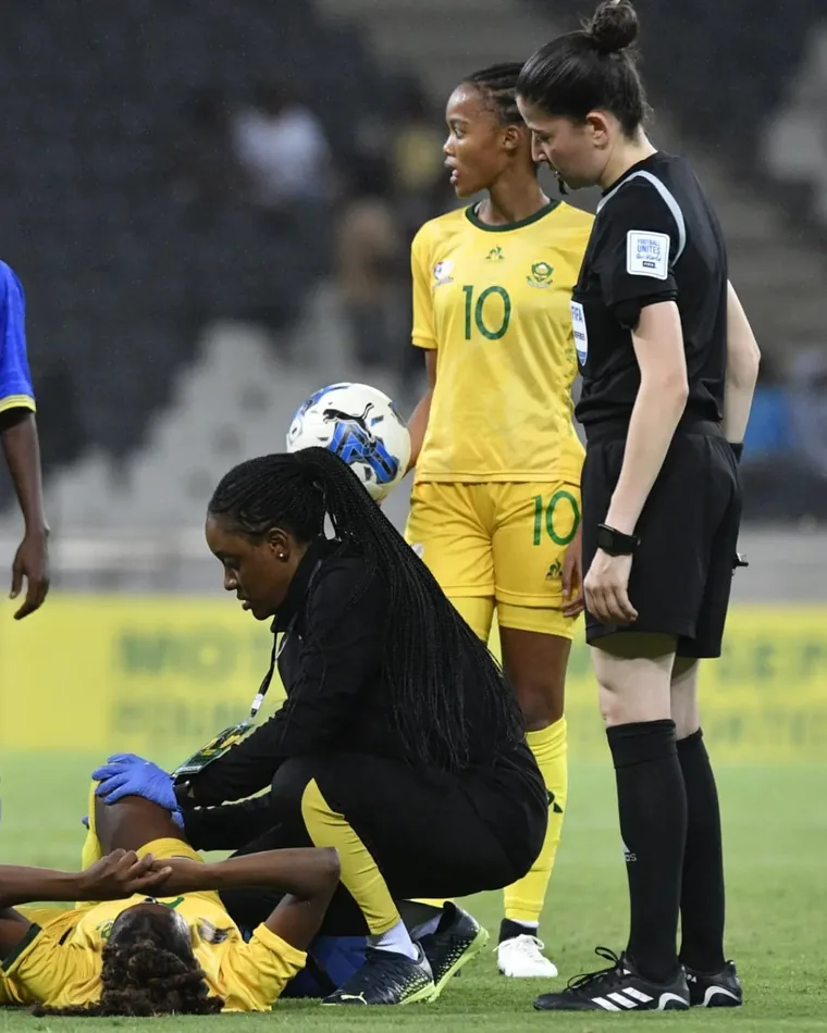 Dr Maesela attending to an injured Banyana Banyana player on the pitch during an international match