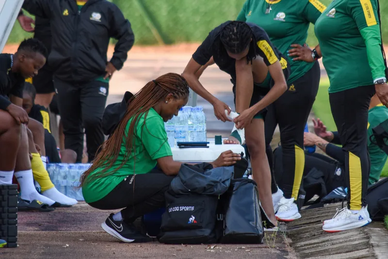 Dr Maesela strapping a Banyana Banyana player's ankle on the sideline